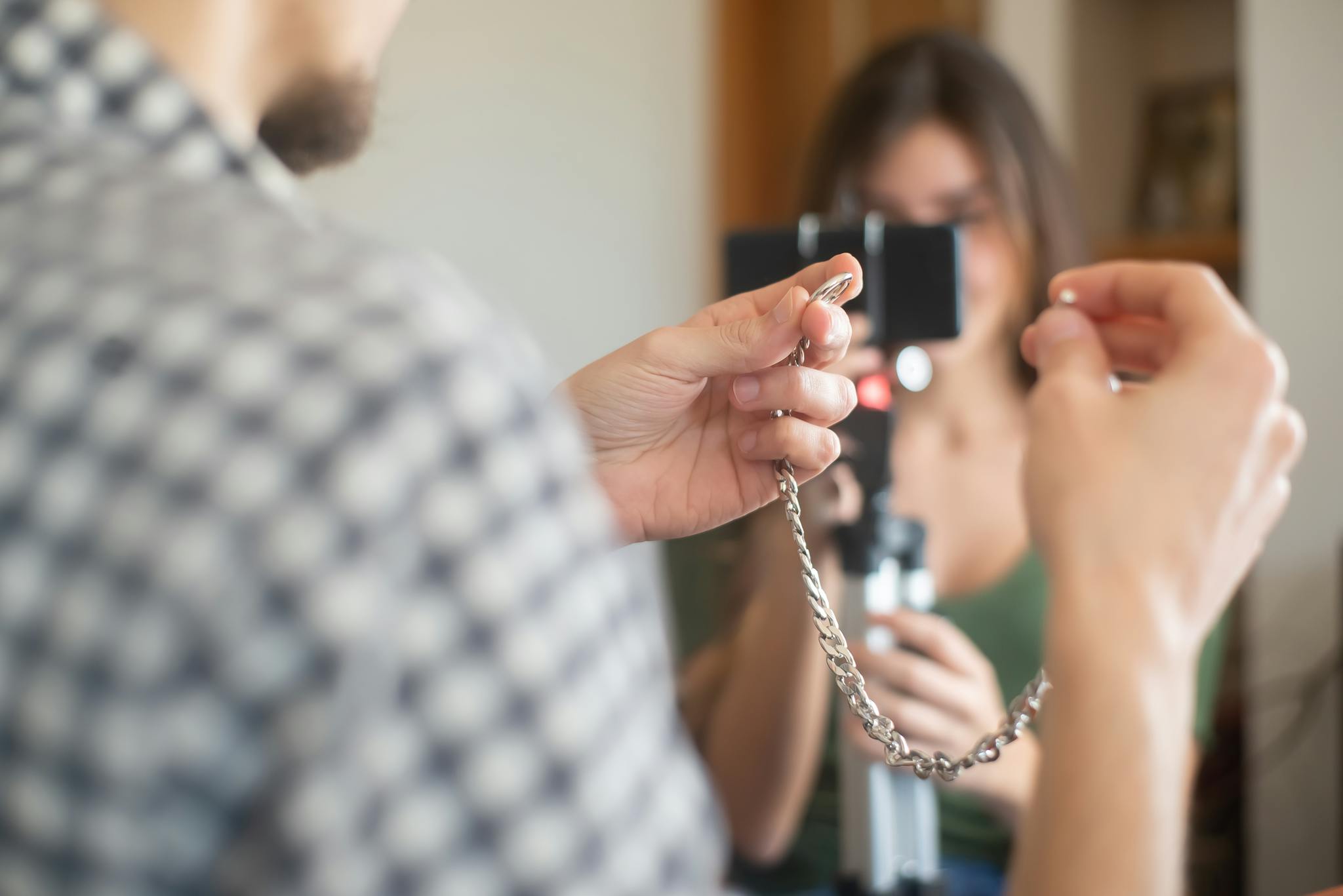 Person displaying a silver chain for an online vlog review in Portugal.